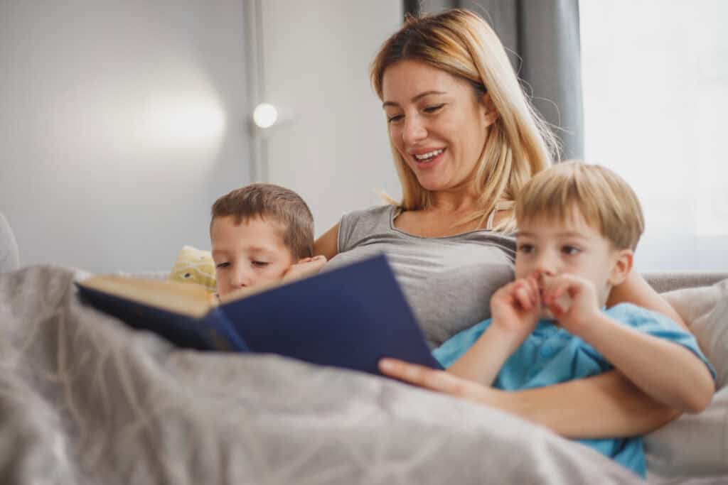 mom reading bedtime story to two young sons