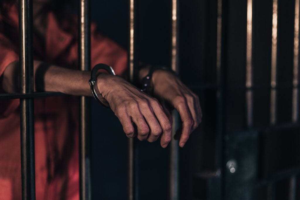 prisoner hands cuffed in cell