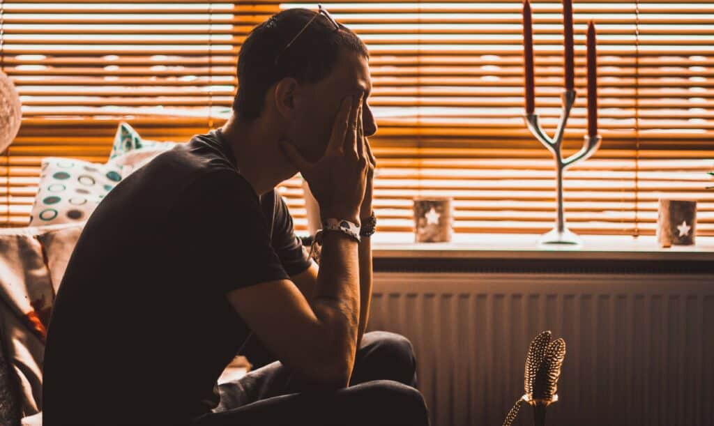 man on couch in dark depressed
