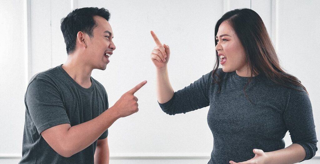 couple pointing at each other and yelling