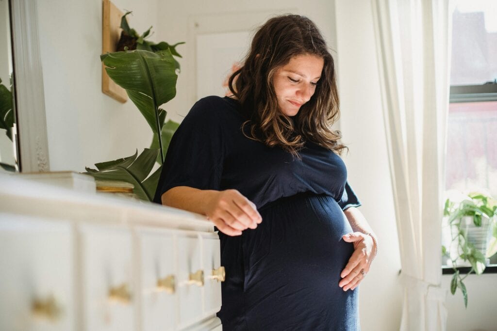 pregnant woman frowning holding belly