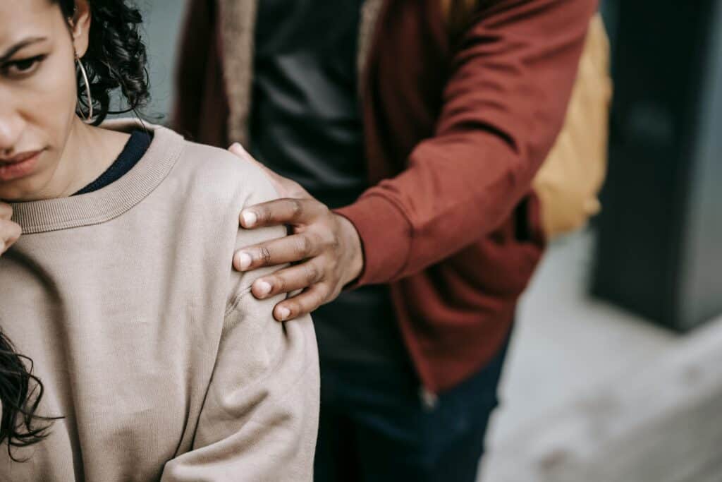 guy with hand on sad girl's shouldee