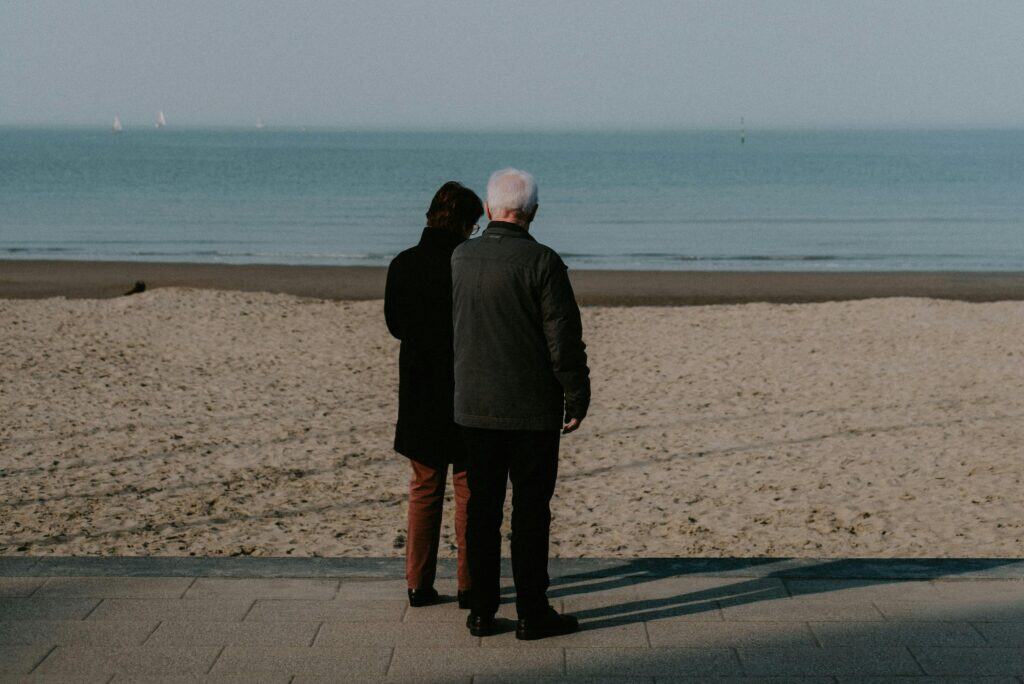 couple backs facing the ocean