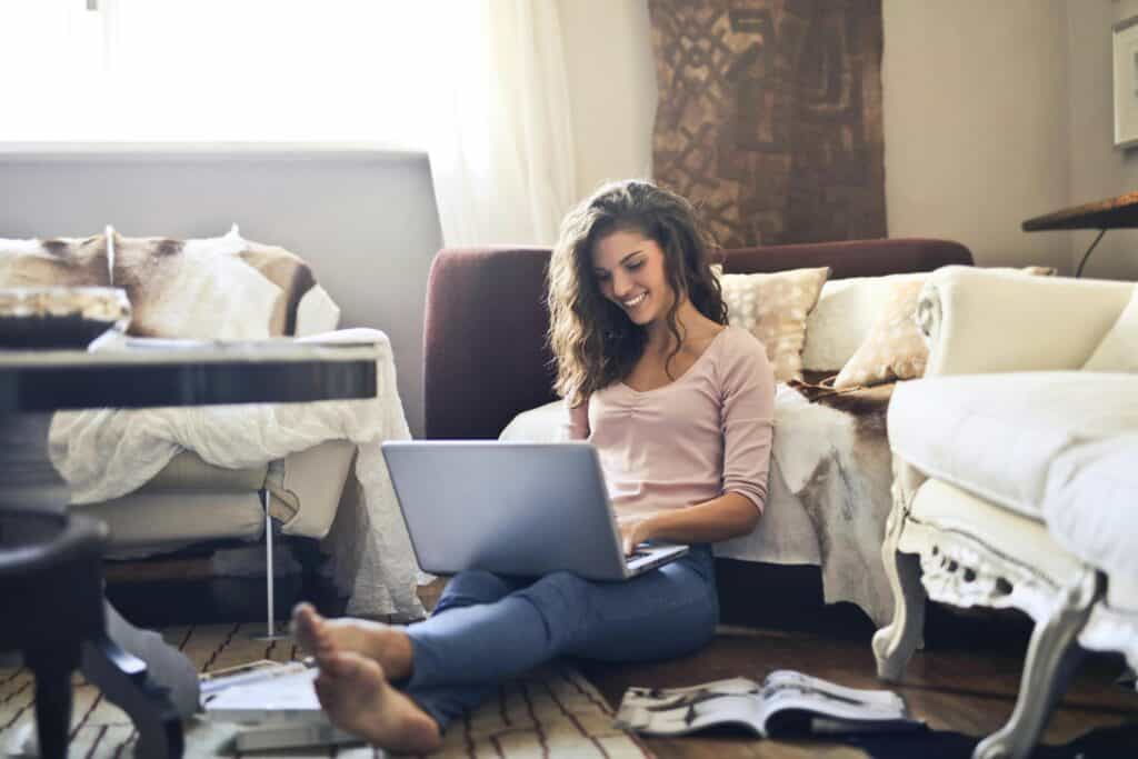 woman smiling sitting on floor with computer
