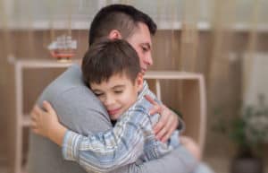 photo of a father and son embracing in forgiveness.
