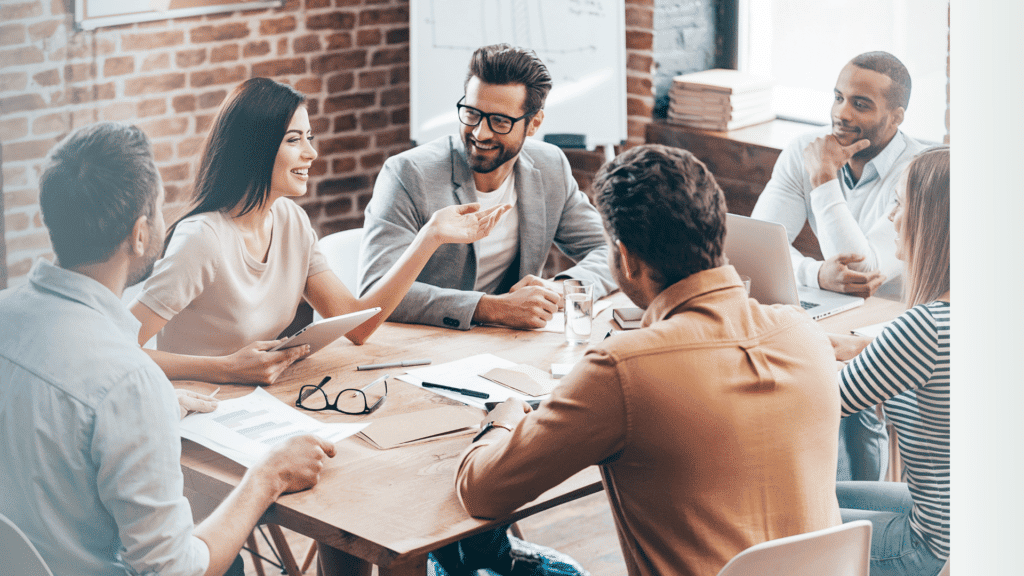 Team of men and women sitting around a table exemplifying the biblical view of work, which is others centered
