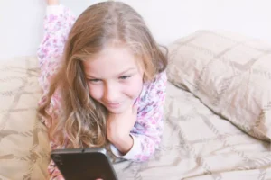 Tween girl on her bed texting teen slang